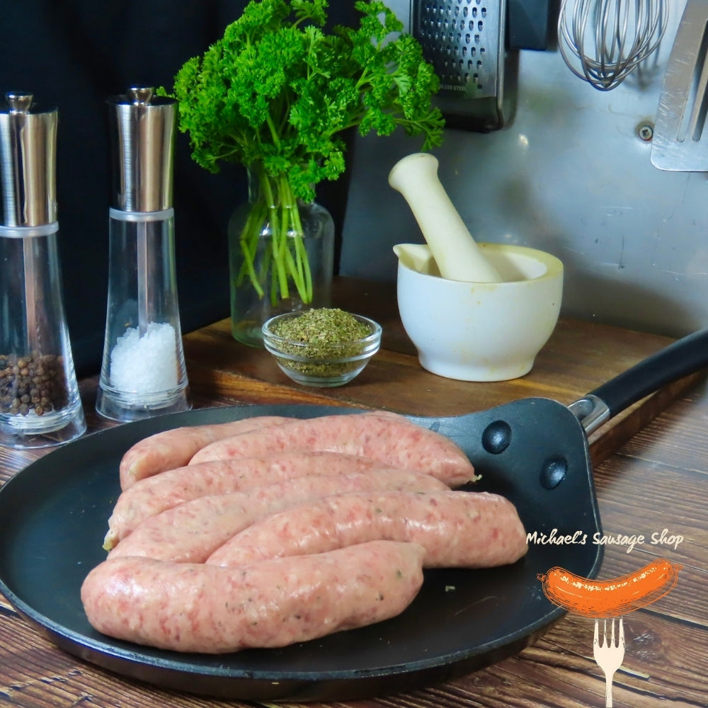 Raw Breakfast sausages on a pan with kitchen items in the background. By Michael's Sausage Shop.