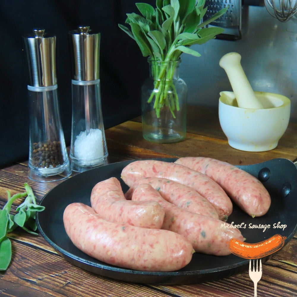 Raw Wiltshire sausages on a black plate with salt and pepper shakers. By Michael's Sausage Shop.