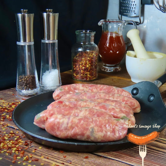 Raw chilli and pepper sausages on a pan with spices and condiments in the background